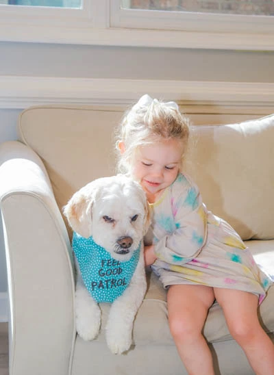 young child sitting with Dobby the Strive Dental Studio therapy dog